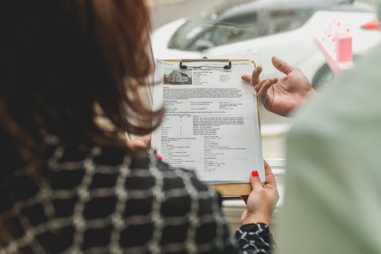 Adviser and investor reviewing property documents together before making an offer